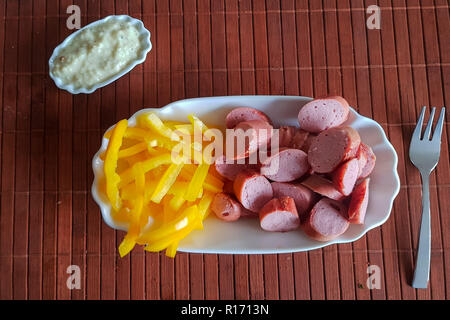 Wiener Würstchen mit gelbe Paprika in Streifen geschnitten als Pommes frites Substitute. Low carb Essen Stockfoto