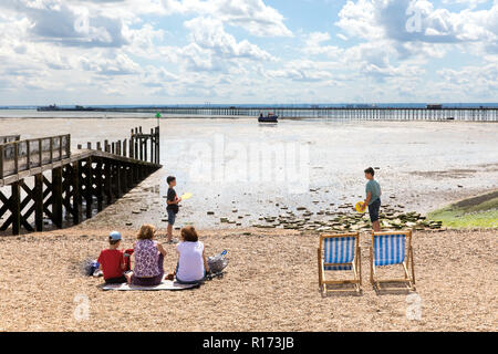 Familie entspannen auf Jubiläum Strand, Southend-on-Sea, mit Southend Pier in der Ferne Stockfoto