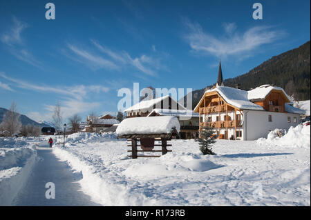 Sonnigen Wintertag. Frau wandern in ländlichen Winterlandschaft, Weißensee, Kärnten, Österreich Stockfoto