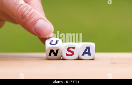 Hand dreht einen Würfel und Änderungen das Wort 'NSA' zu 'USA' Stockfoto