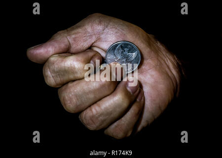 Indonesien, rupiah Münze in der Hand eines asiatischen Person isoliert. Konzept der stiehlt das Geld. Stockfoto