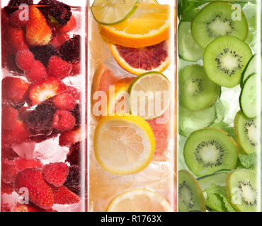 Ganze und aufgeschnittene Obst in Wasser mit Eis Stockfoto