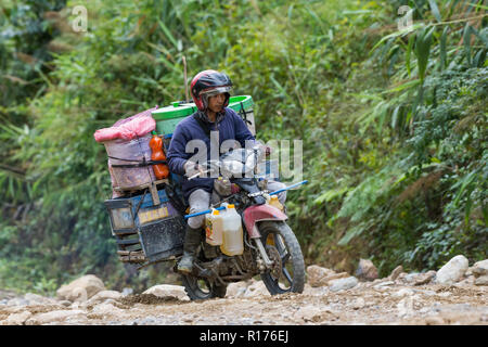 Waren aller Art sind auf Motorrad im ländlichen Gebiet transportiert. Arfak Berg, West Papua, Indonesien. Stockfoto