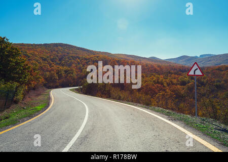 Die Straße im Berggebiet unter die Bäume im Herbst Stockfoto