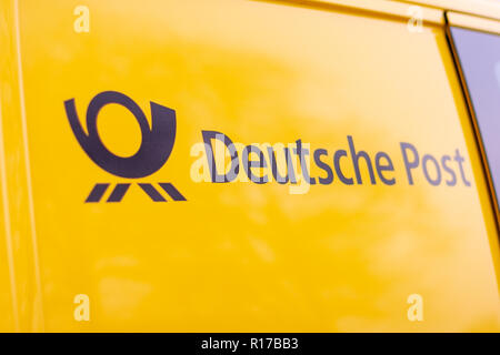 BERLIN/Deutschland - NOVEMBER 9,2018: Logo der Deutschen Post und DHL auf Yellow postcar. Stockfoto