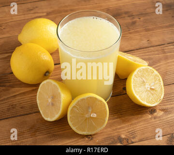 Glas Limonade mit Zitronen auf hölzernen Tisch Stockfoto