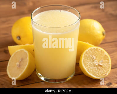 Glas Limonade mit Zitronen auf hölzernen Tisch Stockfoto