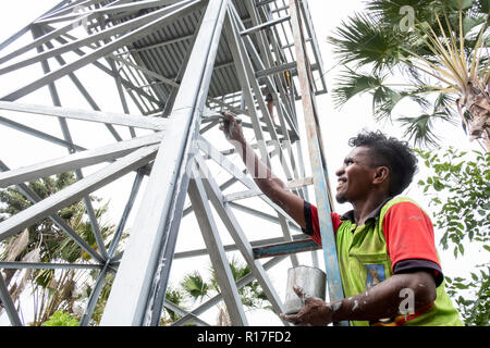 Ein Dorfbewohner malt eine neue Wasserturm in Kasait, Liquica, Timor-Leste. Dies ermöglichte die Dorfbewohner frisches Wasser für die erste Zeit zu haben. Stockfoto