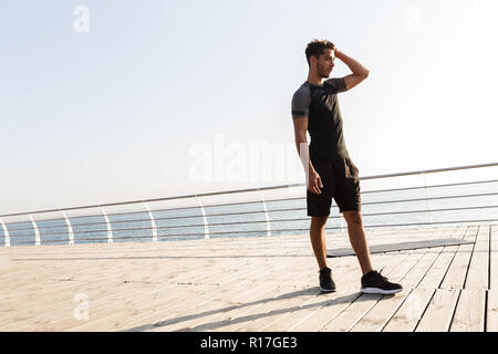 Image der Jungen konzentriert Sport Mann draußen am Strand zur Seite. Stockfoto