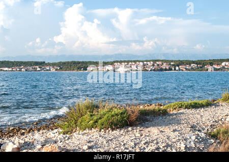 Ein kleines Schiff segeln entlang Zadar Stadt in einer Tiefe blaue Meer Wasser. Sonnigen Sommertag, flauschige Wolken im Himmel Stockfoto