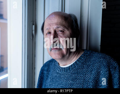 Älterer Mann in seinem 60s Gefühl verzweifelt traurig schauen den ganzen Balkon gesorgt nachdenkliche und einsam zu Hause in alternden Depression Psychische gedrückt Stockfoto