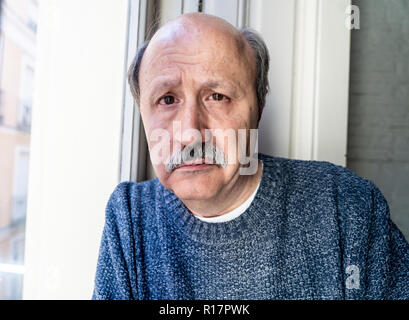 Älterer Mann in seinem 60s Gefühl verzweifelt traurig schauen den ganzen Balkon gesorgt nachdenkliche und einsam zu Hause in alternden Depression Psychische gedrückt Stockfoto