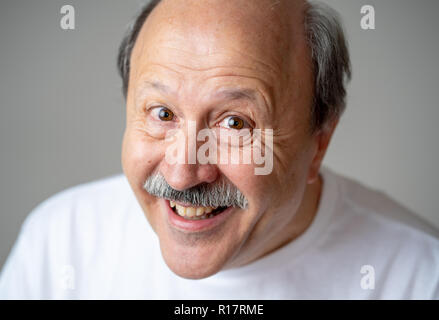 Lächeln und Lachen 60er Jahre alten älterer Mann candid Nahaufnahme portrait in menschliche Gefühle und Mimik Konzept in neutralen Hintergrund isoliert. Stockfoto