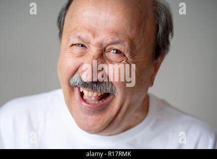 Lächeln und Lachen 60er Jahre alten älterer Mann candid Nahaufnahme portrait in menschliche Gefühle und Mimik Konzept in neutralen Hintergrund isoliert. Stockfoto