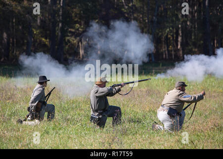 MCCONNELLS, SC (USA) - November 3, 2018: Confederate Reenactors in Uniformen Brand ein Gewehr volley während eines Bürgerkrieges Schlacht Reenactment. Stockfoto