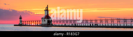 Auf der Sommersonnenwende, der Sonnenuntergang am Lake Michigan zwischen dem Inneren und Äußeren North Pier Leuchttürme in St. Joseph, Michigan. Die Lichter, Laufsteg, Stockfoto