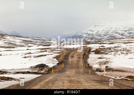 Eine hohe Pass durch verschneite Berge im Osten Islands. Stockfoto