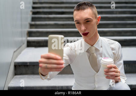 Junge androgyne homosexuellen LGTB Geschäftsmann unter selfie mit Telefon Stockfoto