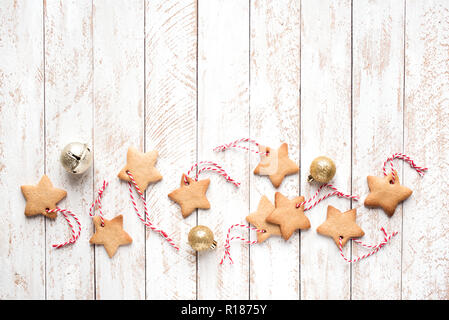 Weihnachten sternförmigen Lebkuchen cookies mit roten Seilen und Kugeln für den Weihnachtsbaum Dekoration auf weißem Hintergrund schäbig, Ansicht von oben, kopieren. Stockfoto