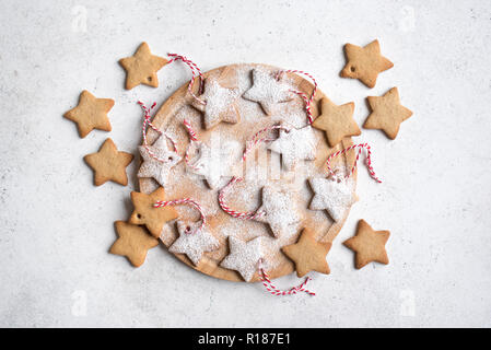 Weihnachten sternförmigen Lebkuchen cookies mit roten Seilen für Christbaumschmuck auf weißem Hintergrund, Ansicht von oben. Stockfoto