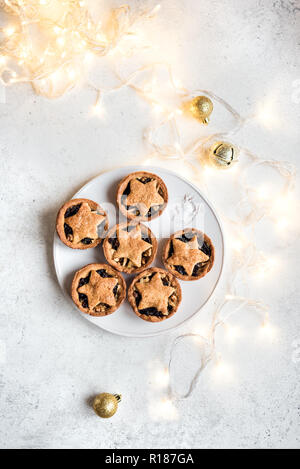 Mince Pies für Weihnachten auf weißem Hintergrund mit Licht, kopieren. Traditionelle Weihnachten Dessert - obstkuchen Hacken. Stockfoto
