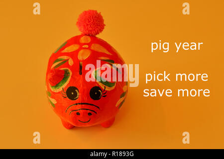 Nahaufnahme Gesicht einer Frau lächelnd Sparschwein aus Papier auf Gold Farbe Hintergrund mit Worten lesen Schwein Jahr Abhol mehr, mehr sparen, Einsparungen Konzept Stockfoto