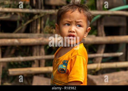 Thakhek, Laos - 21. April 2018: Sorgen Kind in der sunliht in einem abgelegenen Dorf der Provinz Khammouane Stockfoto