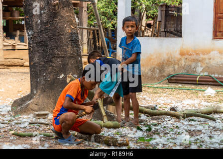 Thakhek, Laos - 21. April 2018: Die Kinder arbeiten mit Holz in einer abgelegenen ländlichen Dorf der Khammouane Provinz. Kinderarbeit ist ein häufiges Problem in der Stockfoto