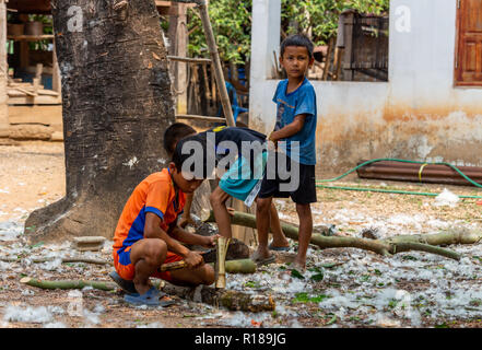 Thakhek, Laos - 21. April 2018: Die Kinder arbeiten mit Holz in einer abgelegenen ländlichen Dorf der Khammouane Provinz. Kinderarbeit ist ein häufiges Problem in der Stockfoto