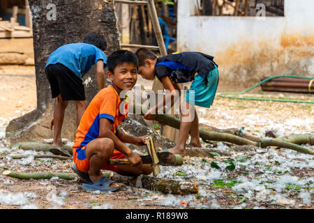 Thakhek, Laos - 21. April 2018: Die Kinder arbeiten mit Holz in einer abgelegenen ländlichen Dorf der Khammouane Provinz. Kinderarbeit ist ein häufiges Problem in der Stockfoto