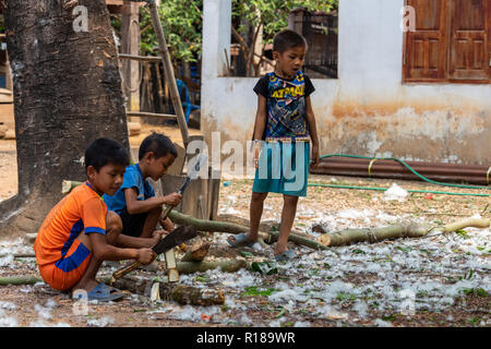 Thakhek, Laos - 21. April 2018: Die Kinder arbeiten mit Holz in einer abgelegenen ländlichen Dorf der Khammouane Provinz. Kinderarbeit ist ein häufiges Problem in der Stockfoto