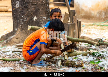 Thakhek, Laos - 21. April 2018: Die Kinder arbeiten mit Holz in einer abgelegenen ländlichen Dorf der Khammouane Provinz. Kinderarbeit ist ein häufiges Problem in der Stockfoto