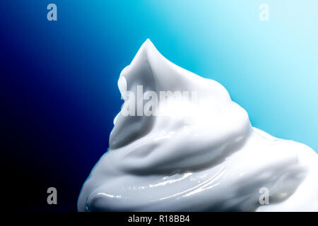 Kosmetische Creme White Close-up Makro Textur auf blauem Hintergrund Stockfoto