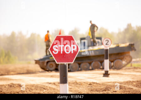 Gruppe von Soldaten auf Panzern auf den Outdoor auf Armee Übungen. Krieg, Militär, Technik und Mensch. STOP-Schild im Vordergrund. Stockfoto