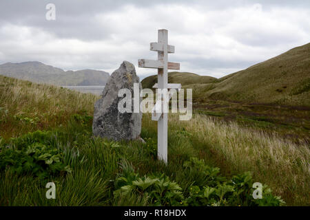 Eine Russisch-orthodoxe Kreuz auf einem Grab auf einem grasbewachsenen Hügel über dem Beringmeer, Unalaska Island, Aleutian Inseln der Vereinigten Staaten von Amerika. Stockfoto
