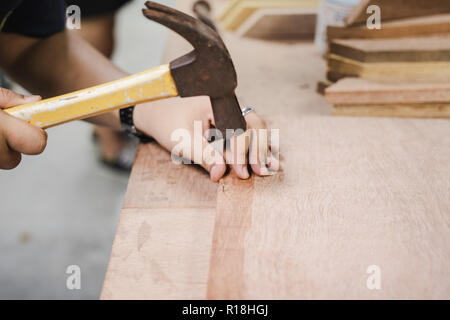 Thai Student schlug einen Nagel mit dem Hammer in Engineering Workshop Klasse Stockfoto