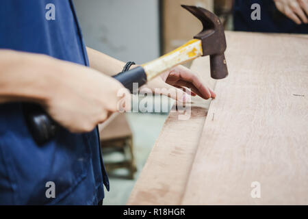 Thai Student schlug einen Nagel mit dem Hammer in Engineering Workshop Klasse Stockfoto