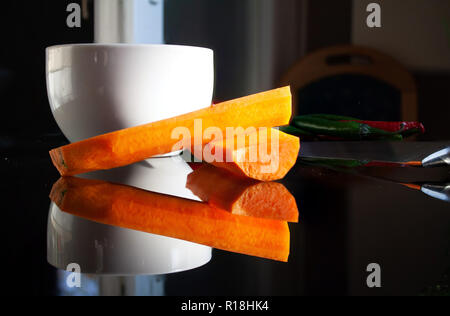 Karotte und Messer auf schwarzem Glas Tisch Stockfoto