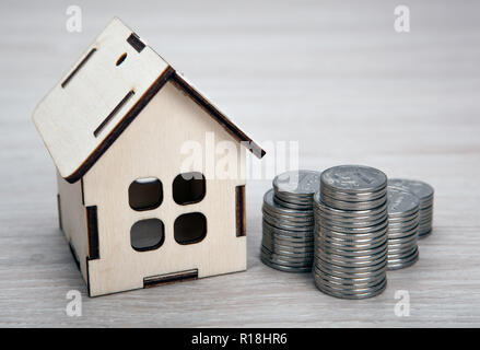 Holz- Miniatur Haus mit Russischen Stapel von Rubel Münzen Nahaufnahme Stockfoto