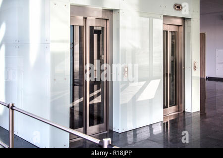 Moderne Glastüren mit Aufzug in einem modernen Geschäftsgebäude Stockfoto