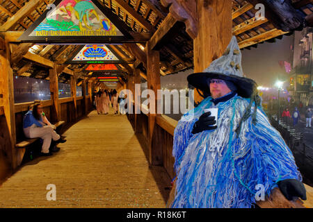 Die Kapellbrücke ist ein überdachter Holzsteg. Die Teilnehmer an den Karneval carnivalat Luzern, Schweiz ausgeliehen Stockfoto