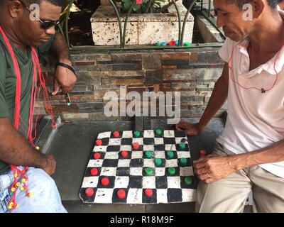 Cartagena, Colobia - März 2018: Zwei Männer spielen Steine auf der Straße in Capurgana, Kolumbien Stockfoto