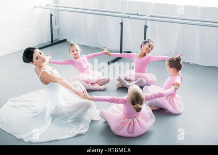 Entzückenden kleinen Ballerinas und junger Lehrer zusammen zu praktizieren in der Ballettschule Stockfoto