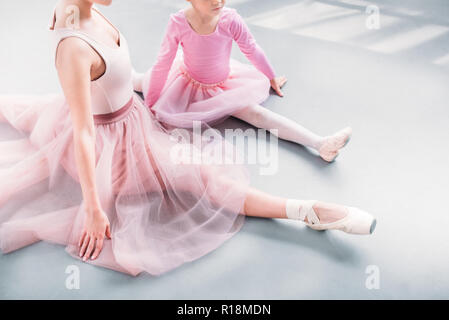 Schuss des Balletts Lehrer und Schüler zusammen Stretching im Ballett Studio 7/8 Stockfoto