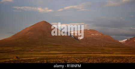 Ein Sommernachtstraum in Island. Ein Berg leuchtet in der Mitternachtssonne. Die in der Nähe von Svinadalsfjall Blönduos. Einen hellblauen Himmel. Stockfoto