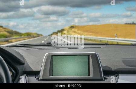 Selektiver Fokus von Generika in der GPS-Navigator gebaut, die auf dem Armaturenbrett eines Autos, die in den Scenic Highway Stockfoto