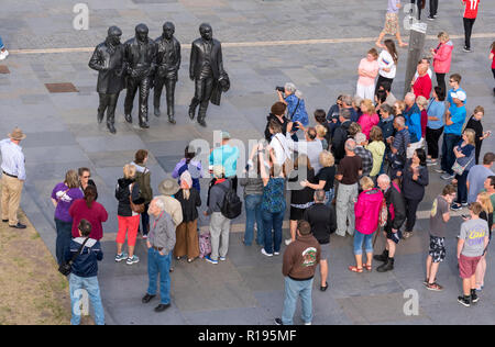 Sightseeing in Liverpool Touristen besuchen die Beatles Statue auf Liverpools Waterfront an der Pier Head. Die riesige Bronzestatue der Fab Four ist eine m Stockfoto