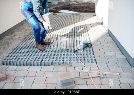 Builder die Bodenplatten auf der Baustelle, 7/8-Bild ohne Gesicht Stockfoto