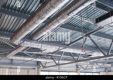 Heizung/Lüftung/Klimaanlage. Lüftung Rohre in Silber Dämmung an der Decke im neuen Gebäude Stockfoto