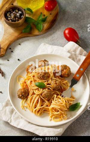 Italienisches Pastagericht. Spaghetti mit Hackbällchen mit Tomatensauce auf Stein oder Beton. Stockfoto